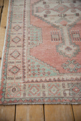 Stepped geometric patterns and distressed pile of vintage Oushak runner in cantaloupe and mint.