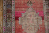 Distressed Oushak rug runner showing madder root red field, fuchsia, and foundation wear.