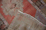 Distressed Oushak runner corner folded back, revealing worn pile, exposed foundation, and numbered reverse.