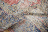 Decorative distressed texture, visible foundation, and muted floral patterns on vintage Oushak.