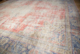 Distressed vintage Oushak rug texture, showing faded rose and ivory with visible foundation.