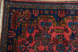 Corner detail of a vintage Mehreban rug showing the sapphire blue floral border and raspberry field.