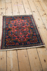 Angled view of a vintage Persian Mehreban rug's raspberry and sapphire floral pattern.