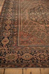 Intricate floral cross-sections of the antique Farahan Sarouk rug's main border and boteh field.