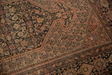 Oversized floral cross-sections, boteh patterns, and soft wear on antique Farahan Sarouk rug.