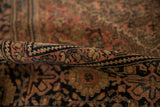 Antique Farahan Sarouk rug's classic border, blush, navy, and saffron floral vinery with even pile wear.
