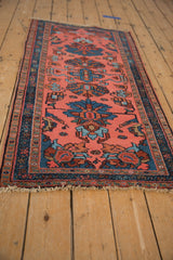 Vintage Mehriban rug corner: dusty pink palmette field, deep teal vine border, uneven fringe.