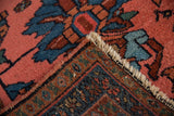 Vintage Mehriban rug with meandering vine border, dusty pink field, and fringed end.