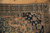 Nuanced floral blossoms and column motif with even wear on an antique Farahan Sarouk rug.