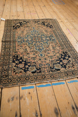 Antique Farahan Sarouk rug corner with unique blush, navy floral motifs and even wear.