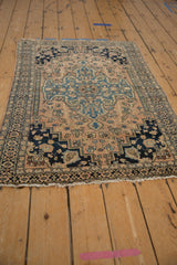 Worn pile of antique Farahan Sarouk rug, showing blush and navy geometric border and fringe.