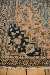 Antique Farahan Sarouk rug: stepped navy column, dusty blush floral field, hand-knotted fringe.