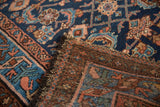 Vintage Mehriban rug's folded edge, revealing Herati pile, hand-knotted foundation, and tattered fringe.