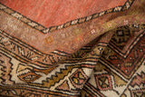 Vintage Hamadan rug detail, showing serrated patterns in dusty coral, sage green, and brown pile.