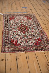 Vintage Persian Dargezine rug from an angle, showing the shield-like medallion and intricate floral design.