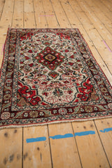 Traditional Persian Dargezine rug with a floral ivory field, shown from a full-length angled view.