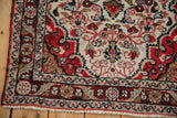 Corner detail of a vintage Persian rug showing the floral border and even hand-knotted pile.