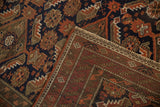 Antique Belouch rug's hand-knotted foundation and serrated geometric border in navy and rust.