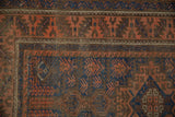 Geometric terracotta and cobalt blue serrated leaf border on this early 20th century Belouch rug.