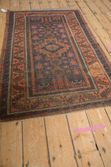 Antique Belouch rug showcasing hook and latch medallion, finned floral blossoms in terracotta and cobalt blue.