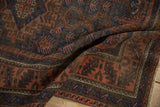 Antique Belouch rug's geometric terracotta and cobalt blue patterns, with distinctive serrated border.