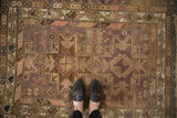 Vintage Caucasian rug, geometric diamond guls and serpent motifs in dusty mauve, brown.