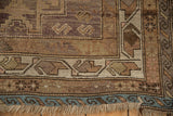 Vintage Caucasian rug's geometric boteh border, blue wave minor border, and fringe.