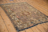 Detail of vintage Caucasian rug with serpent stylized motifs, boteh border, worn pile, and indigo fringe.