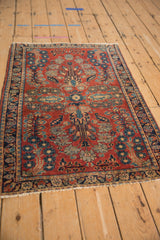 Vintage German Sarouk rug detail: cherry red field, blue quatrefoil blossoms, elaborate floral bud border.