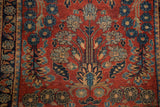 Vintage Sarouk rug's central flowering motif, elongated stems, indigo blossoms.