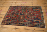 Vintage German Sarouk rug with cherry red field and intricate floral cross-section main border.
