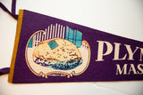 A close-up of the Plymouth Rock graphic on a vintage deep purple felt pennant.