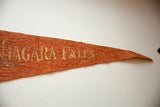 Worn gold lettering and the fibrous texture of the orange Niagara Falls felt pennant.