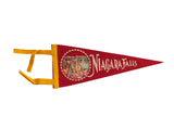 A vintage red felt Niagara Falls pennant with a waterfall graphic and yellow ties.