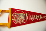 Close-up of the red felt texture, waterfall graphic, and lettering on the vintage pennant.