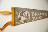 Vintage grey felt pennant featuring a smiling panda graphic and yellow ties.