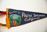 Vintage felt pennant's yellow hand-stitched edge, red loop, and colorful Palm Canyon graphic.