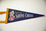 Detail of the vintage clown graphic and yellow felt tie on the blue Shrine Circus pennant.