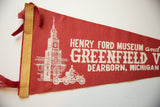 Vintage red felt Henry Ford Museum pennant, showing stitched tan binding and white graphic.