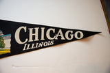 Black felt Chicago Illinois pennant with cream lettering and pointed tip.
