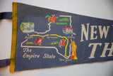 Vintage blue felt pennant showing New York State map, landmarks, and 'The Empire State'.