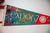 Colorful retro graphics and lettering on the felt surface of a vintage Expo 67 pennant.