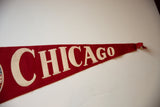 Vintage red felt Chicago pennant, white lettering with handwritten notes, and frayed tip.
