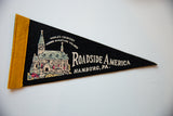 Angled view of the vintage Roadside America felt flag, showing its miniature village graphic.