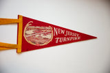 Red felt vintage New Jersey Turnpike pennant featuring the iconic bridge graphic.