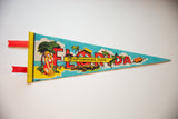 Vintage Florida felt pennant close-up: red tabs, yellow border, retro bather graphic.