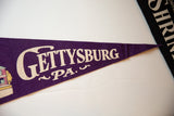 Angled view showing the creased texture and lettering on the vintage Gettysburg pennant.