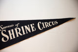 Angled view of the vintage lettering on the dark felt Shrine Circus souvenir pennant.