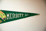 Vintage green felt Merritt BC pennant displaying cream 'MERRITT' text and vibrant fish art.