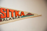 Vintage Sitka Alaska felt pennant showing orange 'KA', retro mountain, and blue water.